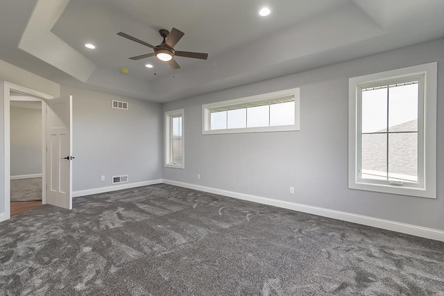 1421 Greenleaf Ct, Sun Prairie, WI 53590 - unfurnished room with a raised ceiling, dark carpet, a ceiling fan, healthy amount of natural light, and recessed lighting