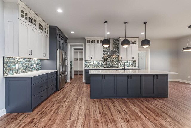1421 Greenleaf Ct, Sun Prairie, WI 53590 - kitchen featuring stainless steel appliances, wall chimney range hood, light countertops, baseboards, and backsplash