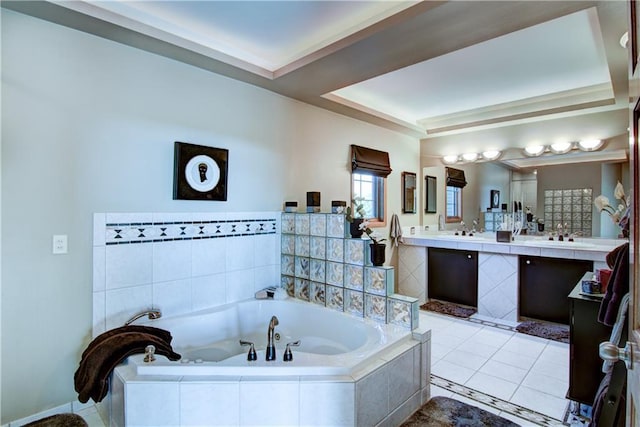 bathroom with tiled tub, tile patterned flooring, and vanity