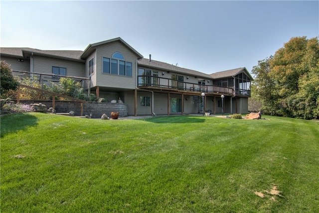 rear view of property featuring a yard and a deck