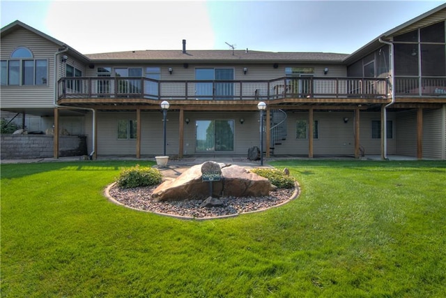 back of house featuring a patio area, a lawn, a wooden deck, and a sunroom