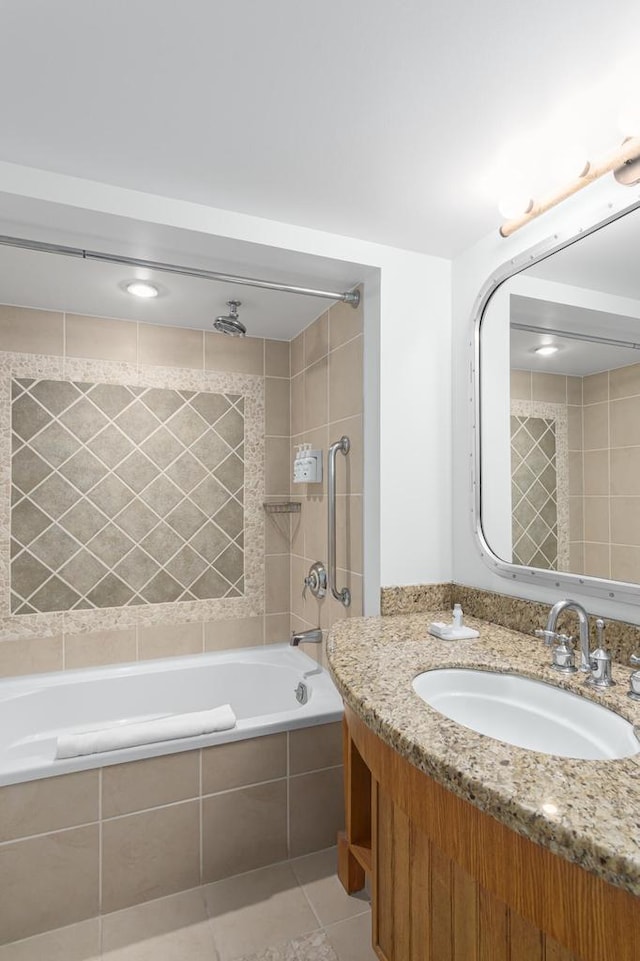 bathroom with tile patterned flooring, vanity, and tiled shower / bath