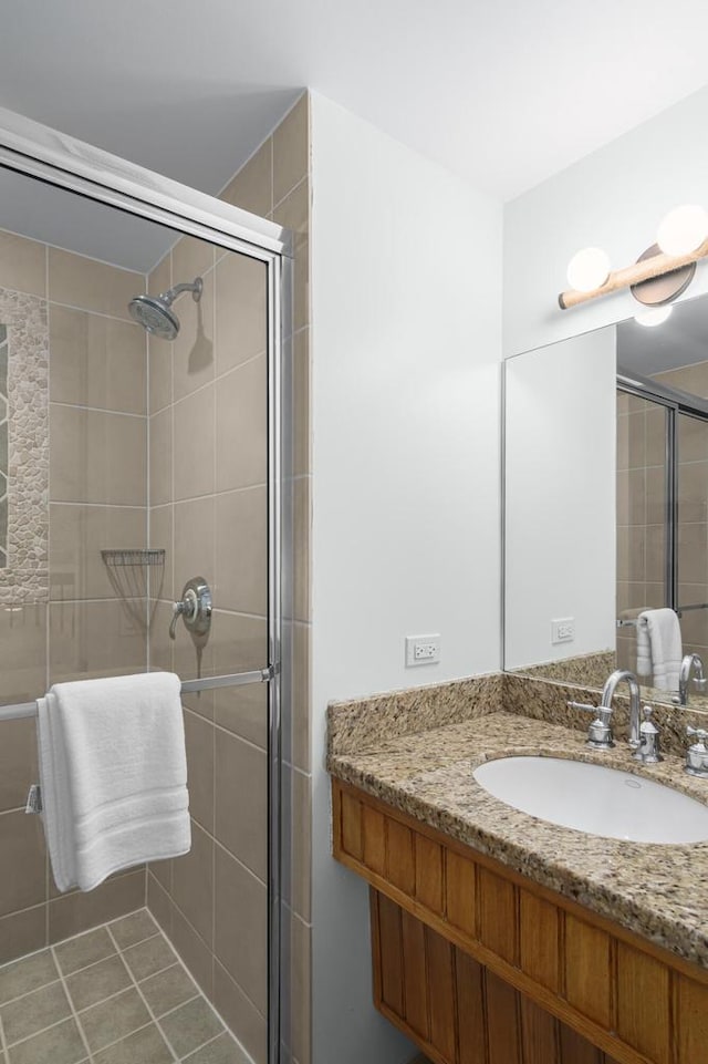 bathroom featuring tile patterned flooring, vanity, and a shower with door