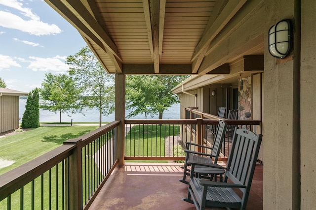 balcony with covered porch and a water view