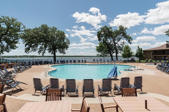 view of pool with a patio area and a water view