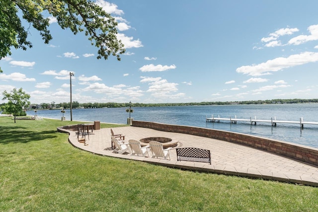 view of dock featuring a yard, a water view, a patio, and an outdoor fire pit