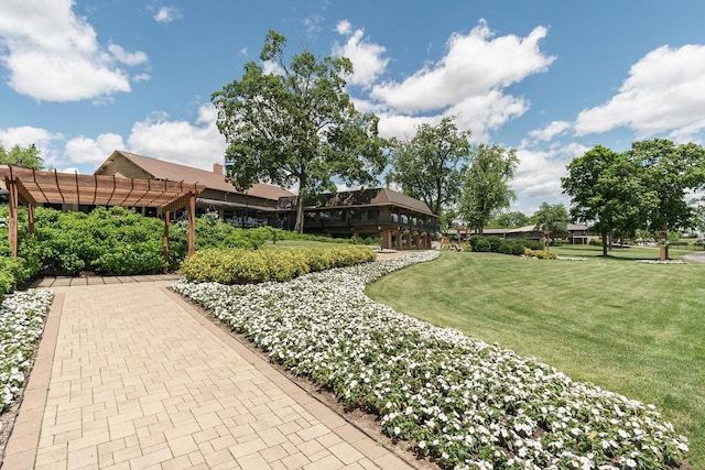 view of community featuring a pergola and a lawn