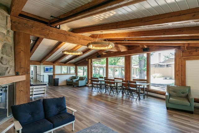 living room featuring lofted ceiling with beams, dark hardwood / wood-style flooring, and a healthy amount of sunlight