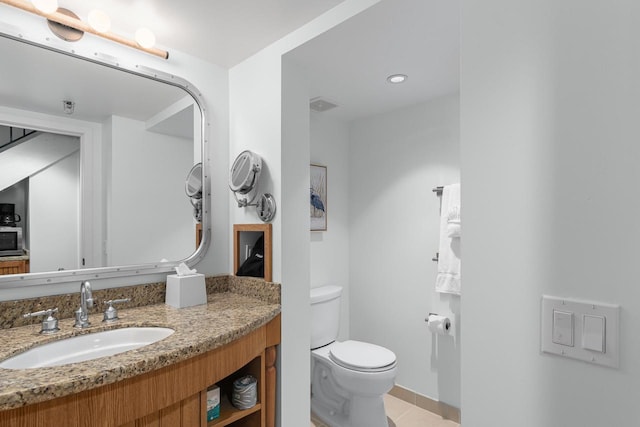 bathroom featuring tile patterned flooring, vanity, and toilet