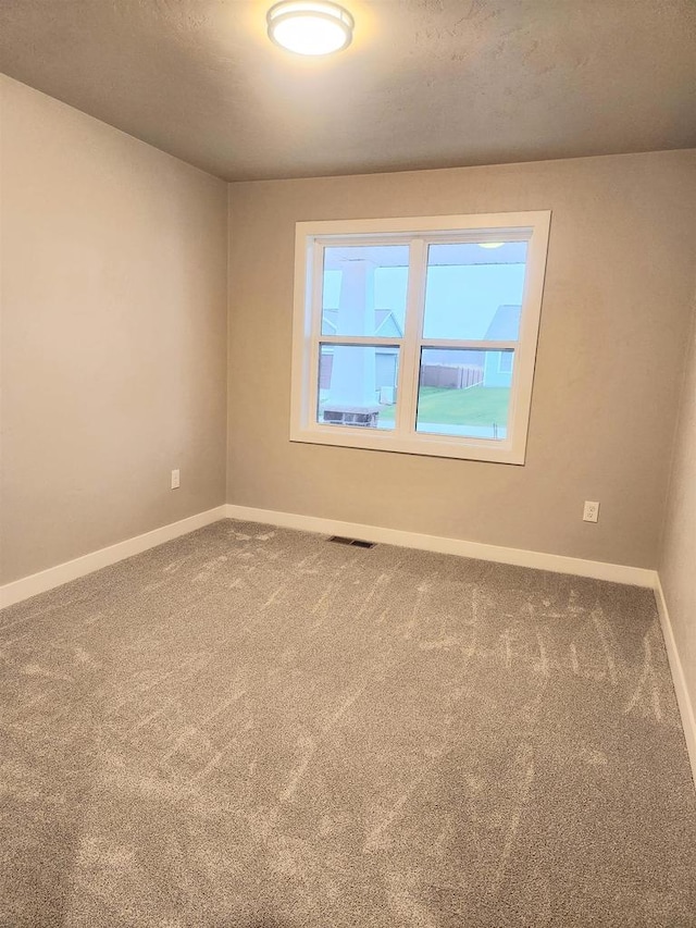 carpeted spare room with a textured ceiling