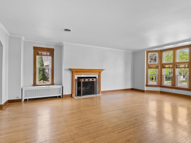 unfurnished living room featuring radiator heating unit, light hardwood / wood-style flooring, and ornamental molding