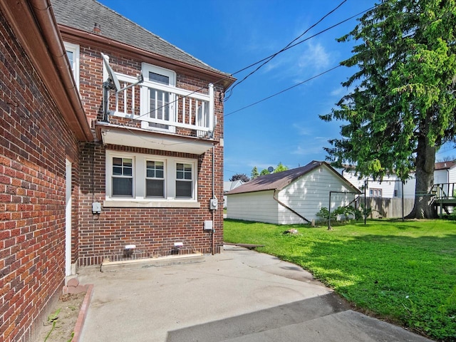 view of property exterior featuring a balcony, a yard, and a patio