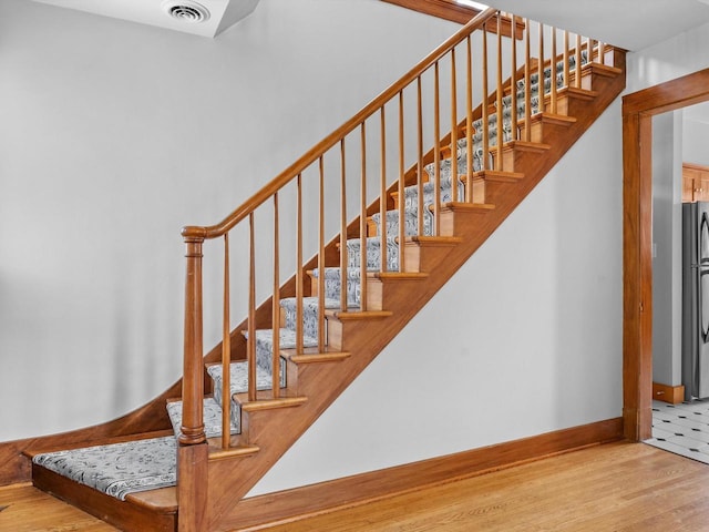 staircase with hardwood / wood-style flooring