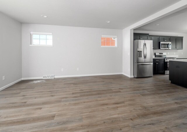 interior space featuring wood-type flooring and appliances with stainless steel finishes