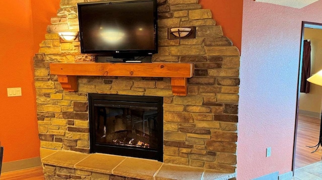 interior details featuring hardwood / wood-style floors and a large fireplace