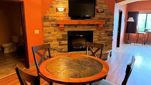 dining area featuring light hardwood / wood-style flooring and a stone fireplace