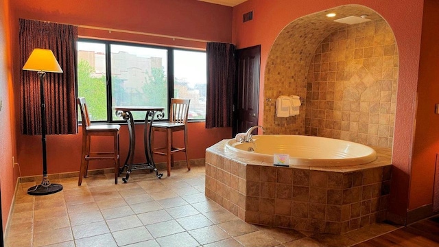 bathroom with tile patterned flooring and a relaxing tiled tub