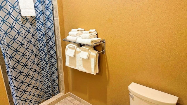 bathroom featuring curtained shower and toilet