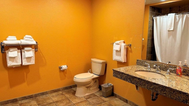 bathroom with walk in shower, sink, and toilet