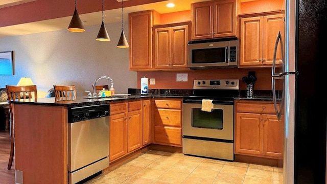 kitchen featuring sink, hanging light fixtures, stainless steel appliances, kitchen peninsula, and dark stone counters