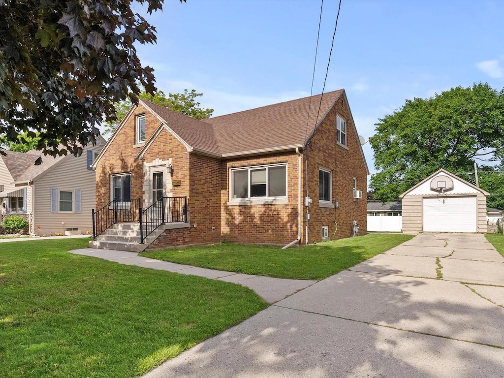 view of front facade featuring a front yard, a garage, and an outdoor structure