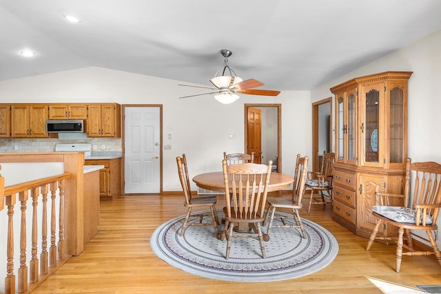 dining space featuring vaulted ceiling, light hardwood / wood-style flooring, and ceiling fan