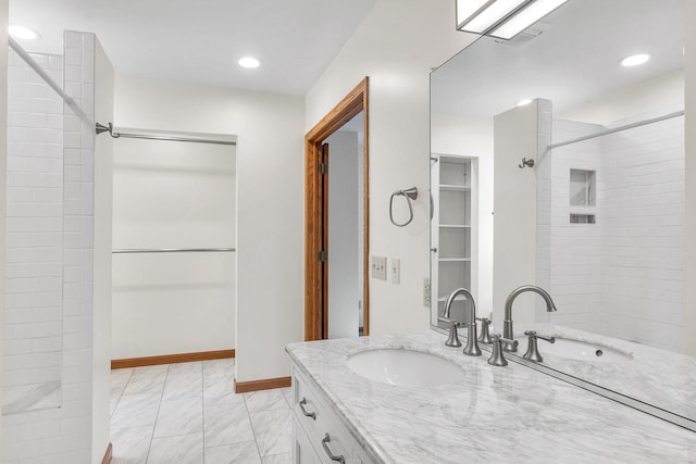 bathroom with vanity and tiled shower