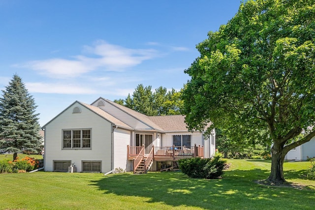 rear view of house featuring a deck and a lawn