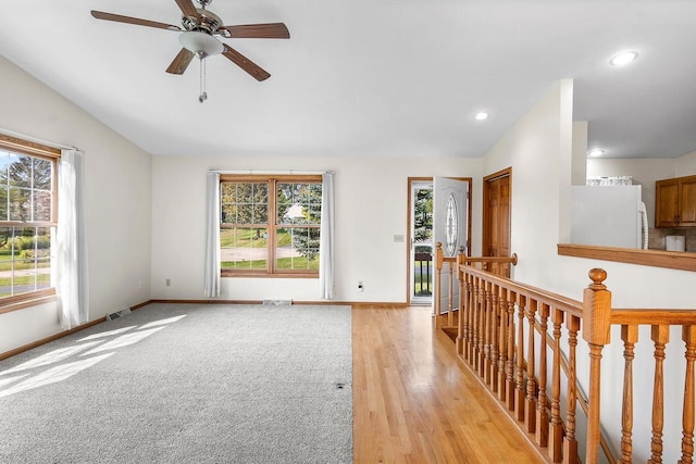 spare room with ceiling fan, light hardwood / wood-style floors, and vaulted ceiling