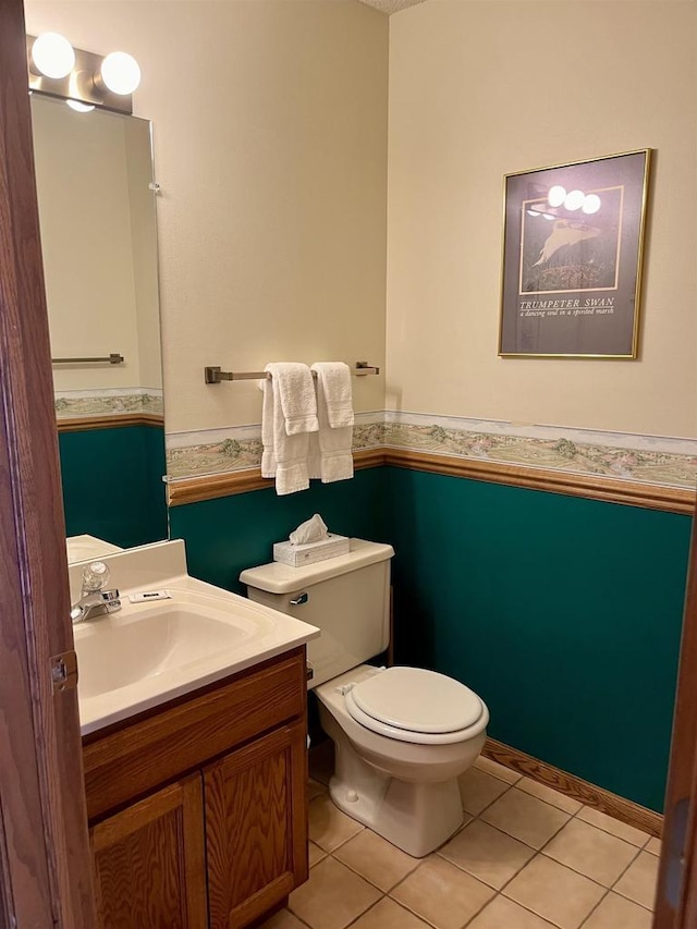 bathroom with tile patterned flooring, vanity, and toilet