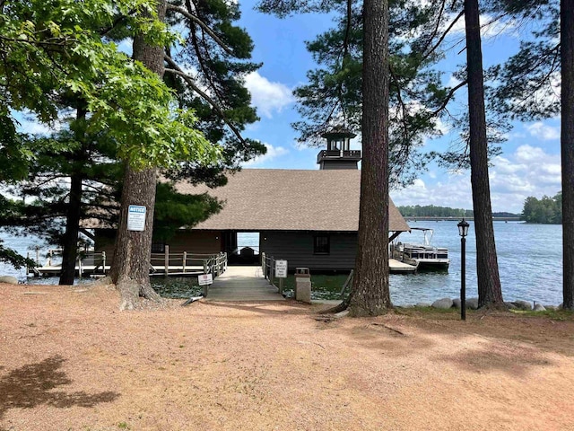 view of front of property featuring a water view and a dock