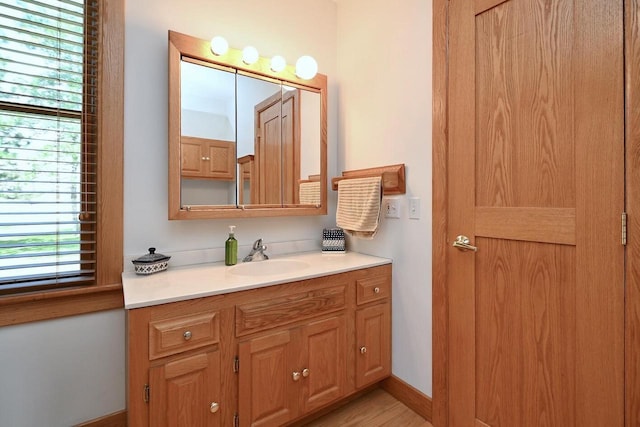 bathroom featuring vanity, wood finished floors, and baseboards