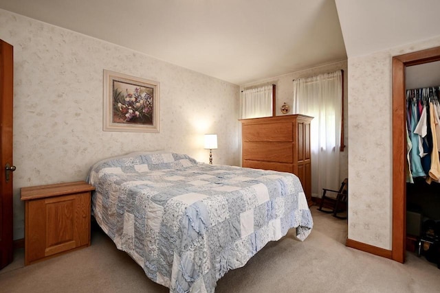 bedroom featuring wallpapered walls, light colored carpet, and baseboards