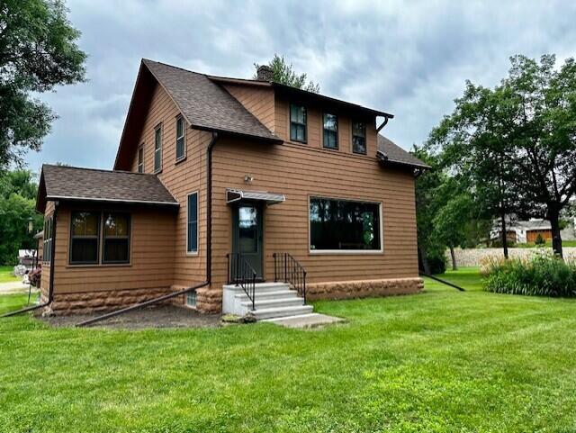 back of house with a lawn