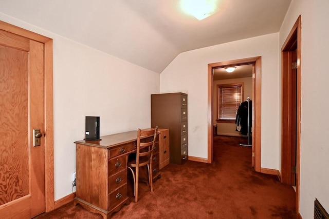 unfurnished office with lofted ceiling, visible vents, dark colored carpet, and baseboards