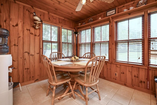 dining space with wooden ceiling, wooden walls, light tile patterned floors, and ceiling fan