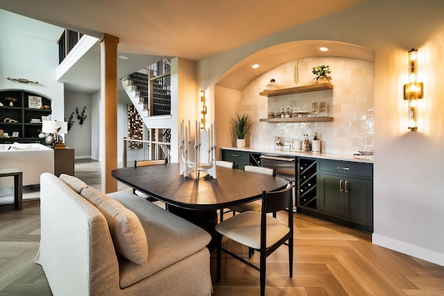 dining space with bar and light parquet floors