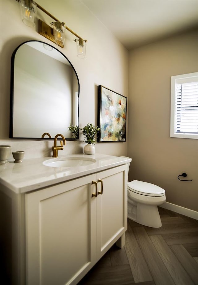 bathroom featuring parquet floors, toilet, and vanity