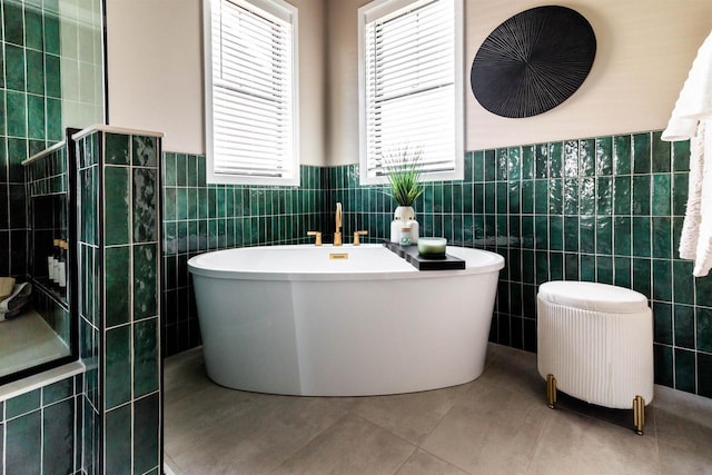 bathroom with tile patterned floors, a tub, tile walls, and radiator