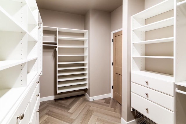 walk in closet with light parquet flooring