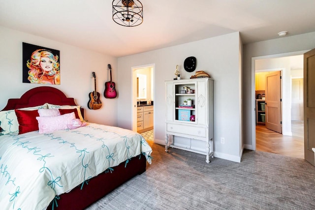 bedroom with ensuite bath and carpet floors