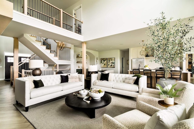 living room with a high ceiling, ornate columns, and parquet floors