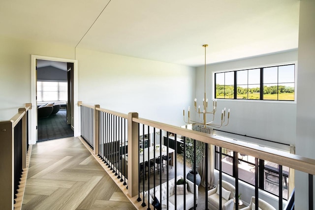 hall with light parquet flooring and a notable chandelier