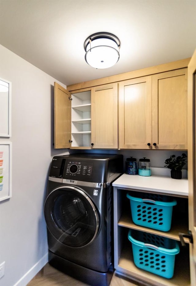 laundry room featuring wood-type flooring, cabinets, and washer / dryer