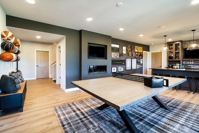 playroom featuring light wood-type flooring and a large fireplace