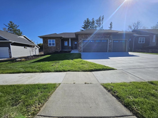 view of front of home with a front lawn, an attached garage, concrete driveway, and stone siding