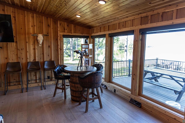 dining area with hardwood / wood-style floors, vaulted ceiling, and wood ceiling