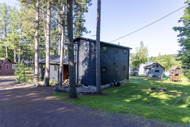 view of home's exterior featuring a playground and a lawn