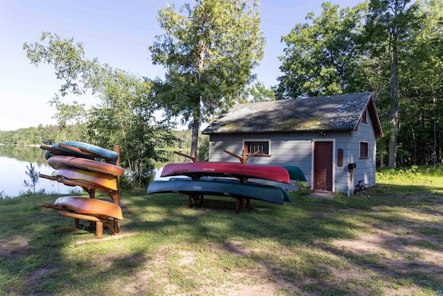 view of yard featuring a water view and an outbuilding