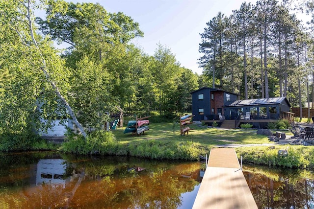 dock area with a lawn and a water view